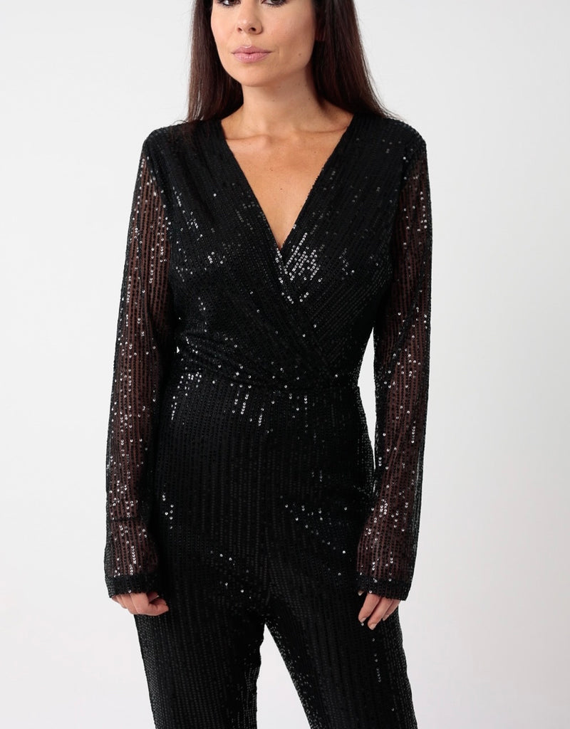 Femme portant une combinaison à sequins noire, doublé, manche en transparence, décolleté