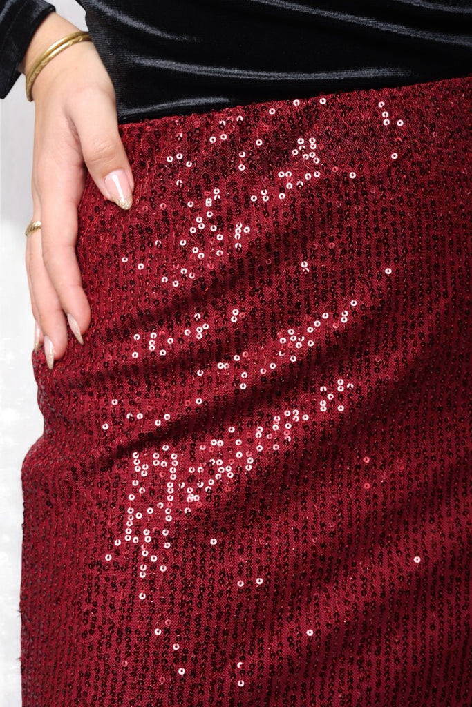 Femme portant une jupe longue bordeaux  à sequins rouges, doublé, coupe droite