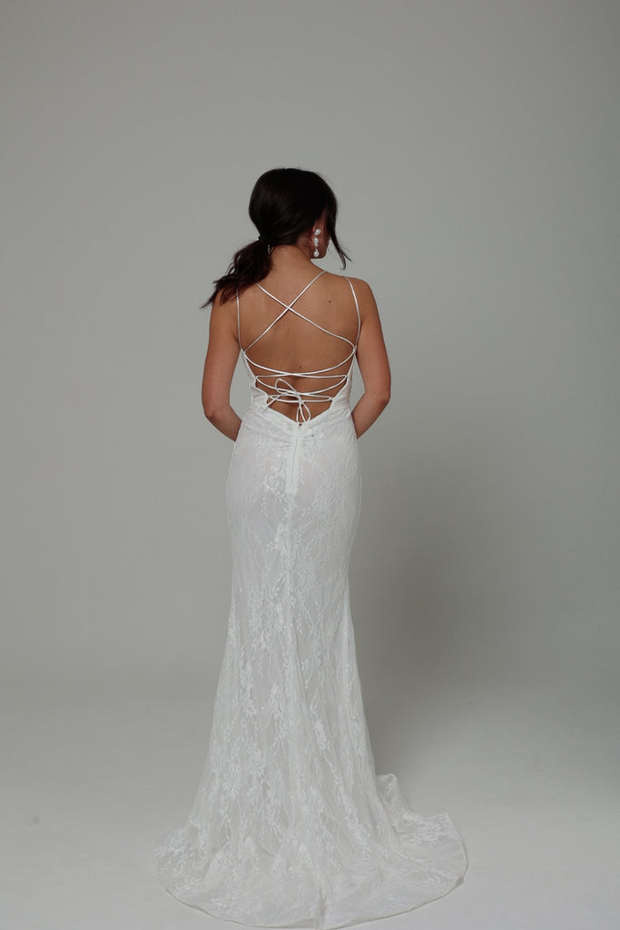 femme portant une robe blanche en dentelle avec des strass