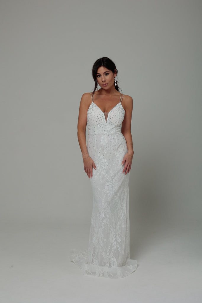 femme portant une robe blanche en dentelle avec des strass