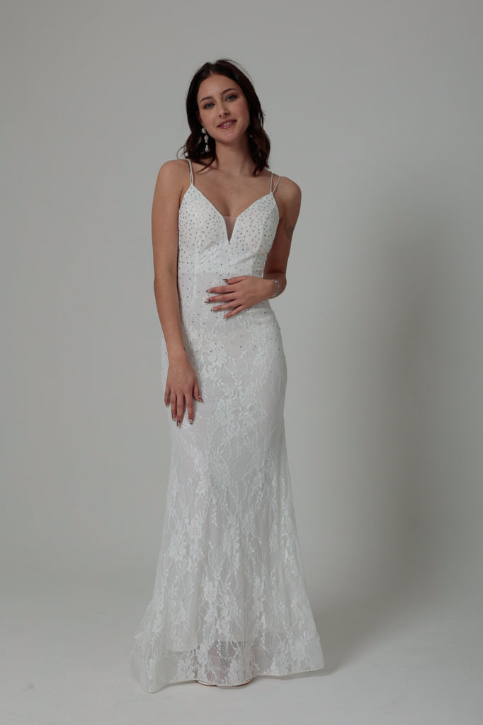 femme portant une robe blanche en dentelle avec des strass